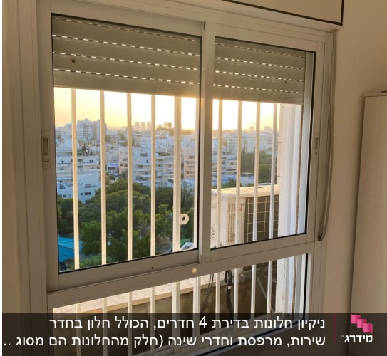חלון עם תריסים ונוף עירוני ברקע